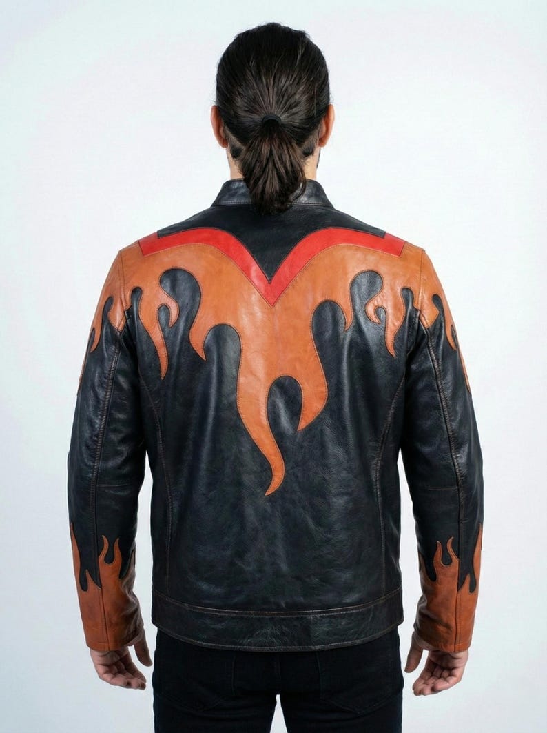 K&ouml;nnte beinhalten: Schwarze Lederjacke mit Flammendesign in Orange- und Rott&ouml;nen. Die Jacke hat einen klassischen Biker-Stil mit Stehkragen und taillierter Passform. Das Flammendesign befindet sich auf dem R&uuml;cken und den &Auml;rmeln.