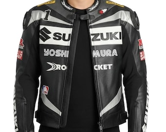 May include: Black and white motorcycle racing jacket with the Suzuki logo and sponsor branding. The jacket features a zip-up front, padded shoulders, and various patches. The jacket is worn by a person.