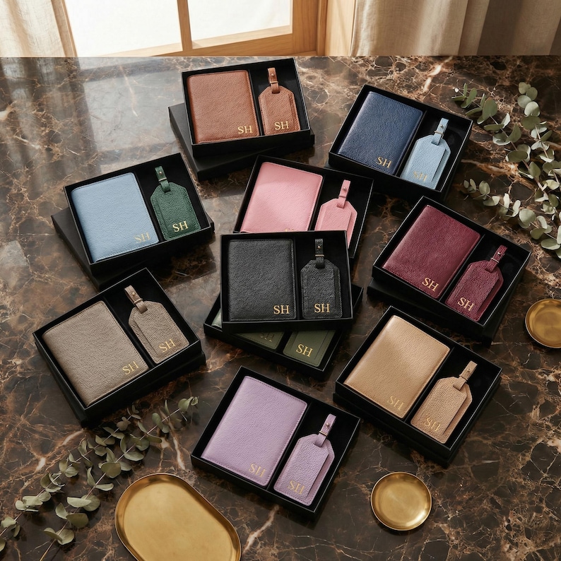 May include: A collection of ten gift sets, each containing a textured passport holder and a matching luggage tag. Each item is embossed with the gold initials SH. The sets come in various colors including brown, navy, light blue, pink, black, burgundy, gray, tan, lavender, and green, all presented in black boxes.