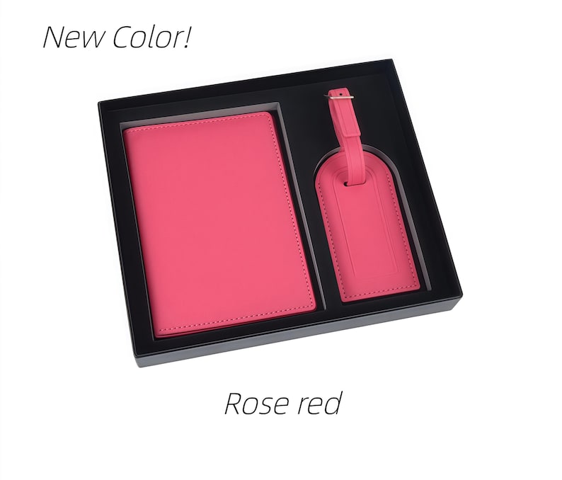 May include: A rose red passport holder and a matching luggage tag presented in a black gift box. The text New Color! appears at the top left and Rose red is printed at the bottom center. Both items feature a smooth, solid-colored finish.