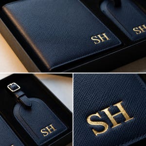 May include: A dark navy blue passport holder and luggage tag set with a textured finish. Both items feature the gold embossed initials SH. The set is presented in a black box, showcasing the matching leather-like material and gold lettering.
