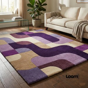 Puede incluir: Una alfombra rectangular con un dise&ntilde;o geom&eacute;trico en tonos morados, beige y crema. La alfombra presenta un patr&oacute;n ondulado y est&aacute; colocada sobre un suelo de madera. El logotipo de la marca Loom es visible en la esquina inferior derecha.