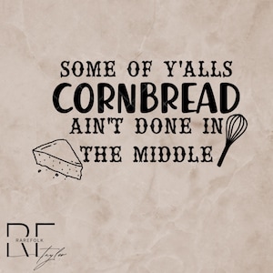 Puede incluir: Diseño gráfico con el texto "SOME OF Y'ALLS CORNBREAD AIN'T DONE IN THE MIDDLE". El diseño incluye una rebanada de pan de maíz y un batidor. El fondo es de color beige claro.