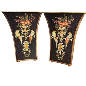 May include: A pair of tall, flared black planters featuring a crackled finish. Each planter is decorated with a central motif of two yellow and orange birds perched on branches, surrounded by green foliage, red berries, and gold floral accents.