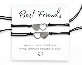 May include: Two black friendship bracelets with silver heart charms. The bracelets are displayed on a white card with the text "Best Friends" and "No matter where life takes us, we will always be connected by heart."