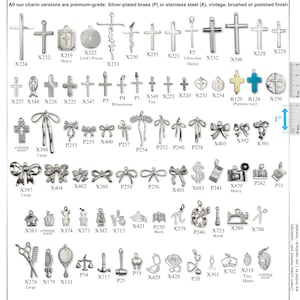 May include: A collection of silver-toned metal charms in various shapes including crosses, bows, tools, and symbols, each labeled with a code. A vertical ruler on the right side shows a 1-inch scale for size reference against the small metal pendants.