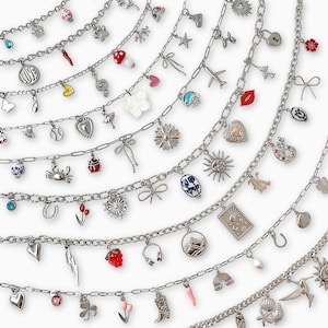 May include: Multiple silver charm necklaces with various pendants, including hearts, flowers, and a lightning bolt. The charms are attached to a chain. The necklaces are displayed on a white background.
