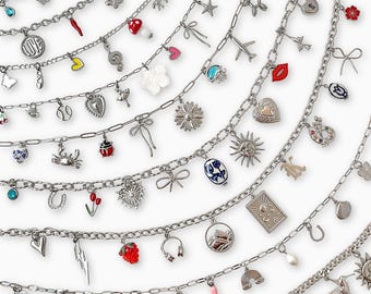 May include: A collection of silver-toned metal charm bracelets featuring a variety of dangling charms including colorful enamel fruits, flowers, animals, celestial symbols, hearts, bows, and various everyday objects attached to link chains.
