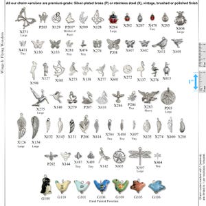 May include: A collection of metal charms in various shapes including butterflies, birds, insects, and wings, labeled with alphanumeric codes. A visible 1-inch ruler indicates scale. The bottom row features hand-painted porcelain animal charms.