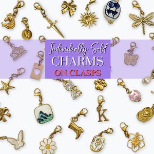 May include: A collection of individually sold charms on clasps. The charms include a gold horse head, a sword, a sun, a crown, a starfish, a heart, a butterfly, a paw print, a bow, a daisy, and more. The charms are in gold, silver, and white.