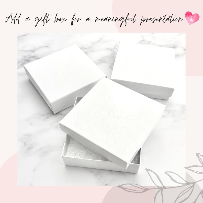 May include: Three white gift boxes on a white marble surface. One box is open and shows a white foam interior. The text 'Add a gift box for a meaningful presentation' is above the boxes.