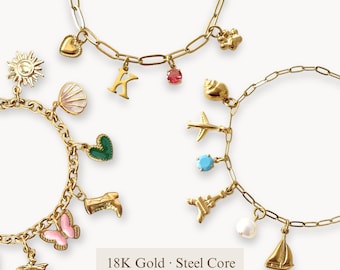 Op de afbeelding: Drie goudkleurige schakelarmbanden met diverse bedels, waaronder een zon, schelp, hart, vlinder, letter K, vliegtuig, Eiffeltoren en zeilboot. Tekst: 18K Gold · Steel Core Anti-Tarnish & Waterproof.