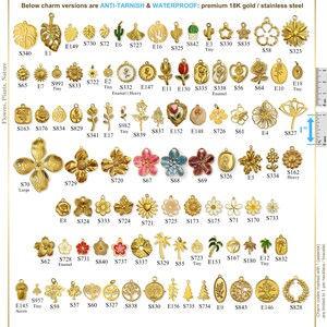 May include: A collection of gold-colored charms featuring floral, plant, and nature-themed designs. The charms include various flowers, leaves, trees, and other botanical elements. Some charms have enamel details. The image includes a ruler for size reference.