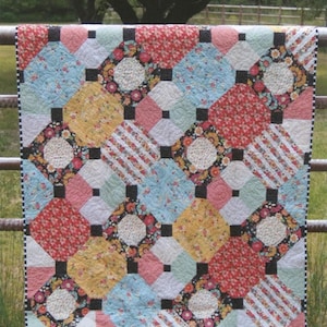 May include: A colorful quilt with a geometric pattern, featuring squares and diamonds in various floral and patterned fabrics. The quilt is displayed outdoors, with the text "JUST SMASHING #303" and "2abbeylane.com" visible.