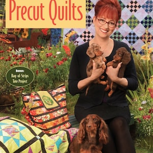 May include: A book titled "M'Liss Rae Hawley's Precut Quilts" with a woman holding two brown and white dachshund puppies. The book cover features a yellow background with the title in red and black letters. The woman is wearing a black shirt and a black skirt. The book cover also features a bonus project: a bag-of-strips tote project. The book cover also features the text "FRESH PATCHWORK DESIGNS USING FAT QUARTERS, CHARM SQUARES & STRIP SETS".