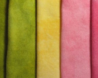 May include: A close-up of several fabric swatches in a row. The colors include purple, green, yellow, pink, and red. The fabric has a soft, textured appearance.