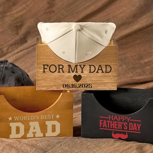 May include: Three rectangular wooden hat storage boxes. The top box is light wood with the text FOR MY DAD, a heart icon, and 06.16.2025. The bottom left is medium wood with WORLD'S BEST DAD. The bottom right is black with HAPPY FATHER'S DAY and a red mustache.