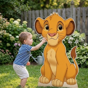 May include: A large, flat, die-cut cardboard cutout of a young lion character with golden-orange fur, large ears, and a tufted tail. The character is depicted in a seated position with a light-colored chest and paw pads, featuring a detailed cartoon face.