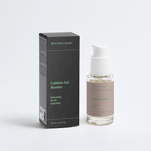 Op de afbeelding: Een huidverzorgingsproductset met een zwarte doos en een heldere fles met een witte pomp. Op de doos staat "Wild Mint Goods" en "Caffeine Gel Booster". De fles toont ook de productnaam en belangrijkste kenmerken: verfrissend, zonder olie en hydraterend.
