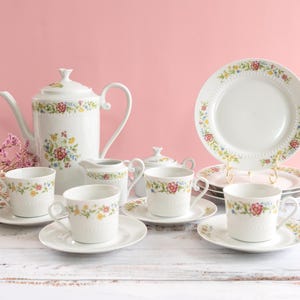 May include: A set of three ceramic mugs with a speckled, matte finish. The mugs are in shades of cream, light gray, and dark gray. Each mug has a simple, minimalist design, perfect for coffee or tea.