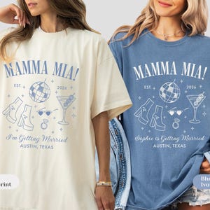 May include: Ivory and blue jean t-shirts with a light blue graphic that reads "MAMMA MIA!" with a disco ball, martini, and other wedding-themed illustrations. The text "I'm Getting Married" and "Sophie is Getting Married" are also included.