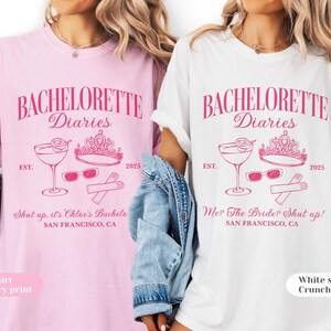 May include: Two t-shirts, one pink and one white, with a pink graphic. The graphic includes the text "BACHELORETTE Diaries", a cocktail, sunglasses, a crown, and the year 2025. The pink shirt says "Shut up, it's Chloe's Bachele" and the white shirt says "Me? The Bride? Shut up!"