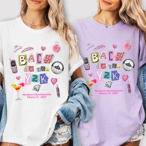 May include: A white and a light purple t-shirt featuring a collage graphic with the text BACH to the Y2K and Madison's Bachelorette Miami, FL 2027. The design includes a flip phone, disco ball, cocktail, diamond, heart, and hair accessories.