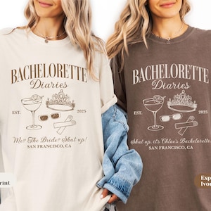 May include: Two t-shirts, one ivory and one espresso, feature the text "BACHELORETTE Diaries" with a cocktail, crown, sunglasses, and utensils graphic. The ivory shirt says "Me? The Bride? Shut up!" and the espresso shirt says "Shut up. it's Chloe's Bachelorette!"