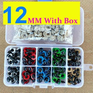 May include: A clear plastic organizer box filled with various sizes and colors of craft safety eyes. The box contains black, red, blue, green, and tan eyes. The text "12 MM With Box" is displayed in the image.