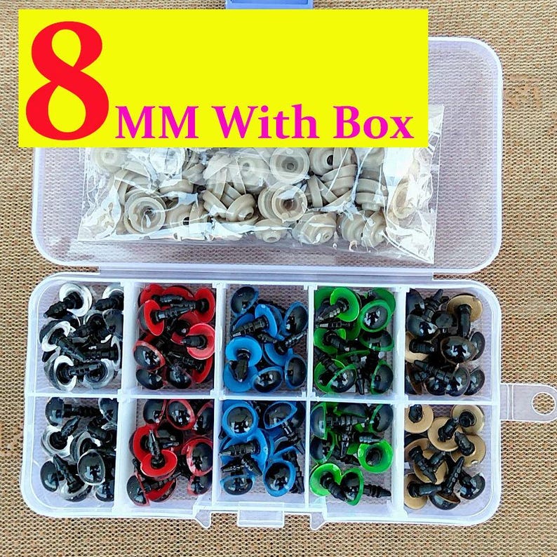 May include: A clear plastic organizer box filled with various colored craft eyes. The box contains black, red, blue, green, and tan eyes, along with a bag of tan eyes. The text "8 MM With Box" is displayed on a yellow banner.