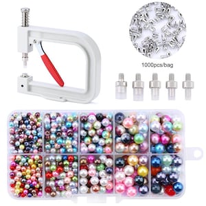 May include: A white manual pearl setting machine with a red handle, five metal screw-in attachments, a bag containing 1000 silver-toned metal studs, and a clear plastic storage box filled with assorted multi-colored round faux pearls.