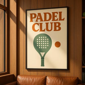 May include: A framed poster with the words "PADEL CLUB" in orange letters. The poster features a green padel racket and an orange ball on a cream background. The poster is hanging above a brown leather sofa.