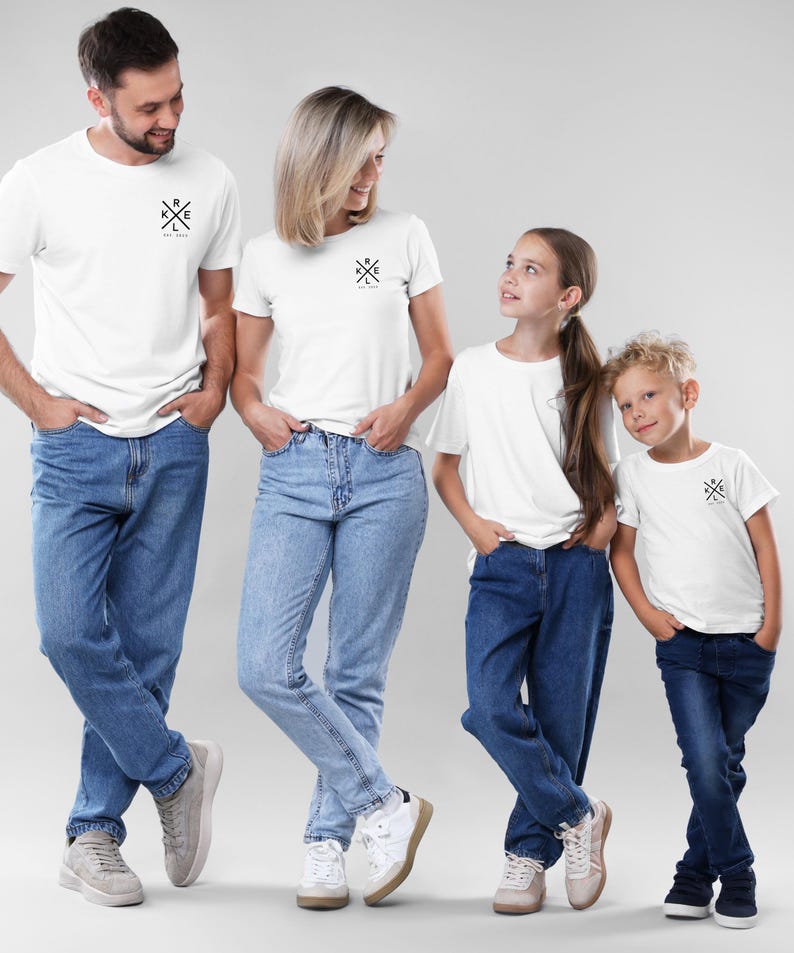 May include: Four people wearing matching white t-shirts and blue jeans. Each shirt has a small black graphic and the text "R K L E Est. 2020". The group is standing in front of a light grey background.