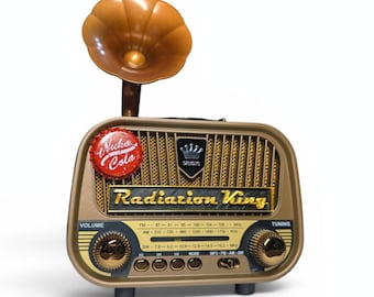 May include: A vintage-style radio in gold and brown tones, featuring a speaker with a decorative horn. The radio has the text "Radiation King" and "Nuka Cola" branding. It includes volume and tuning knobs.