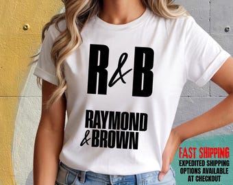 May include: White Bella Canvas t-shirt with the text "R&B RAYMOND & BROWN" in black. The shirt has short sleeves and is being worn by a person. The words "FAST SHIPPING" are also visible.