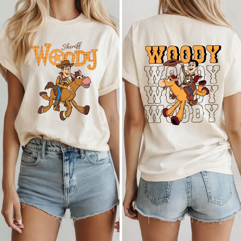 May include: Cream-colored t-shirt featuring a cartoon image of Woody riding a horse, with the text "Sheriff Woody" in orange. The back of the shirt repeats the word "Woody" with the same graphic.