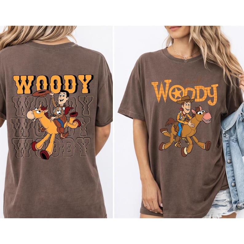 May include: Brown t-shirts featuring a graphic of Woody from Toy Story riding a horse. The word "Woody" is printed in a western-style font above the graphic on the front and back of the shirts.
