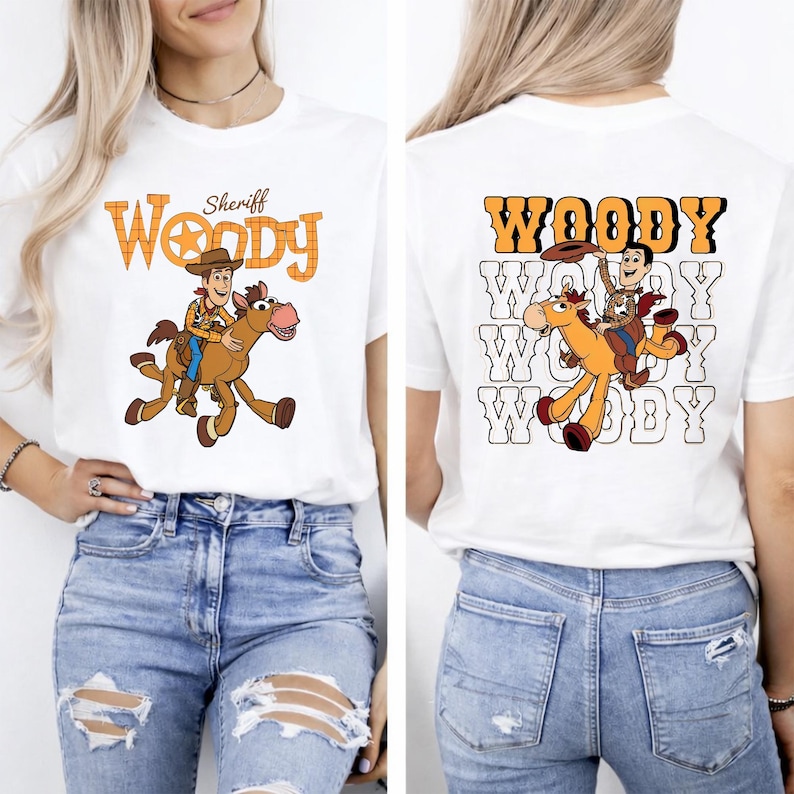 May include: White t-shirt featuring a cartoon graphic of Woody riding a horse. The front of the shirt has the word "Woody" in orange and a sheriff's star. The back of the shirt repeats the Woody graphic and the word "Woody" in orange.