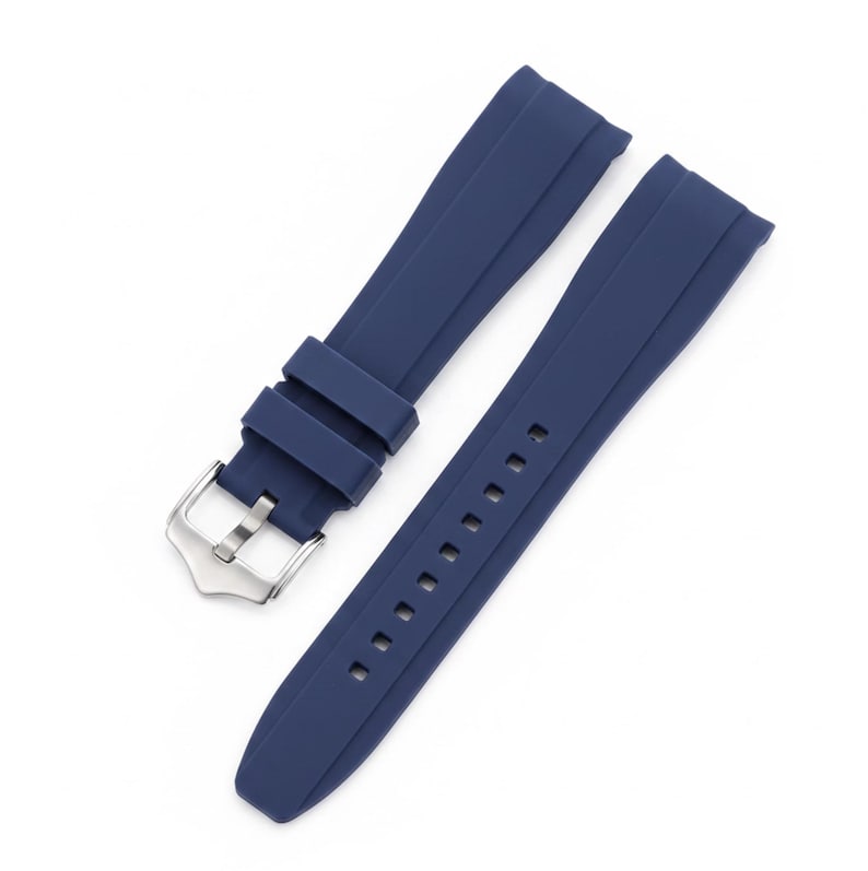 K&ouml;nnte beinhalten: Ein marineblaues Uhrenarmband aus einem glatten, flexiblen Material. Das Armband besteht aus zwei Teilen, von denen eines eine silberfarbene Metallschnalle und zwei verschiebbare Schlaufen sowie das andere eine Reihe von Einstelll&ouml;chern aufweist.
