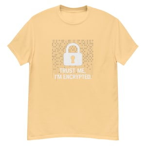 Puede incluir: Camiseta amarillo claro con un candado blanco y el texto "TRUST ME, I'M ENCRYPTED" en blanco. El candado está sobre un fondo de código binario. La camiseta está hecha de un material suave y cómodo.