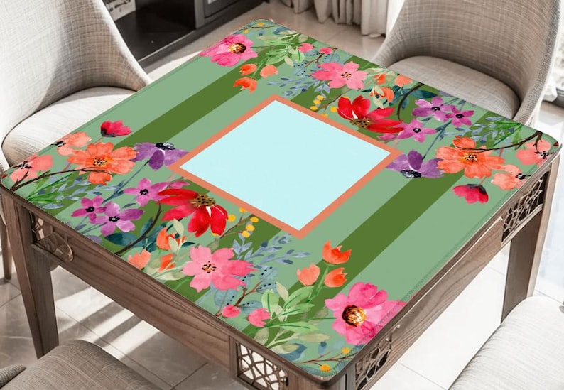 Puede incluir: Mesa cuadrada de madera con dise&ntilde;o floral. La tapa tiene un fondo verde claro con rayas verticales y un cuadrado azul claro central. El patr&oacute;n floral incluye flores rosas, rojas y moradas. La mesa mide aproximadamente 76 cm cuadrados.