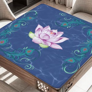 May include: A square table with a dark blue surface featuring a watercolor lotus flower and peacock feather accents. The table is made of wood and has a decorative design on the legs.