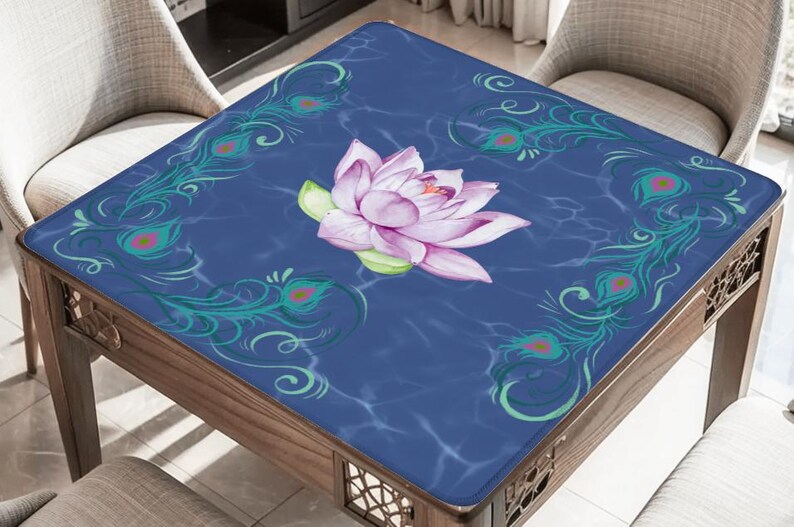 May include: A square table with a dark blue surface featuring a watercolor lotus flower and peacock feather accents. The table is made of wood and has a decorative design on the legs.