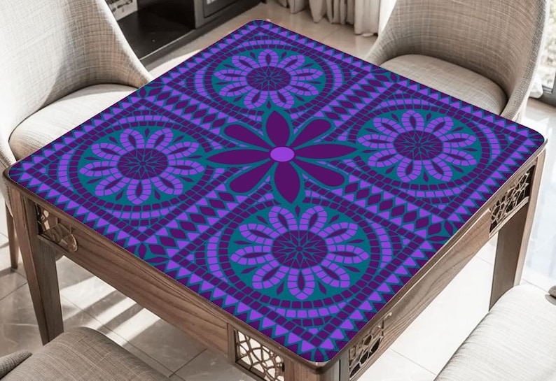May include: A square wooden table with a decorative floral pattern in shades of purple and teal. The table's surface features a mosaic-like design with large flower motifs and geometric shapes. The table is surrounded by chairs with light-colored upholstery.