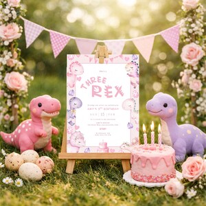 K&ouml;nnte beinhalten: Eine Geburtstagsszene mit Dinosaurier-Thema, mit einer h&ouml;lzernen Staffelei mit einer "Three Rex"-Einladung. Rosa Dinosaurier-Pl&uuml;schtiere, ein Kuchen mit Kerzen und dekorative Eier sind auf dem Gras angeordnet. Ein rosa-wei&szlig;es Banner h&auml;ngt im Hintergrund.