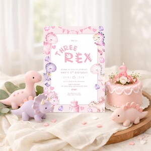 K&ouml;nnte beinhalten: Eine rosa Geburtstagseinladung mit dem Text "Three Rex" und Dinosaurier-Illustrationen. Die Szene umfasst Spielzeugdinosaurier, einen kleinen Kuchen mit einer Kerze mit der Zahl 3 und herzf&ouml;rmige Konfetti. Die Einladung ist f&uuml;r Amys 3. Geburtstag.