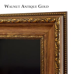 Puede incluir: Primer plano de un marco rectangular con acabado de nogal y detalles en oro antiguo. El marco tiene detalles ornamentados a lo largo de los bordes y el texto "Walnut Antique Gold" en la parte superior.