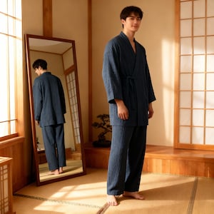 Puede incluir: Un conjunto de pijama de algod&oacute;n acolchado azul marino, que incluye una parte superior envolvente con cintur&oacute;n y pantalones a juego. El atuendo se usa en una habitaci&oacute;n con un espejo grande y elementos de dise&ntilde;o tradicionales japoneses.