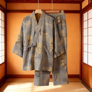 May include: A gray kimono-style robe and matching pants set. The fabric features a gold landscape pattern. The robe has a tie closure, and the pants have an elastic waistband. The set is hanging on a wooden hanger.