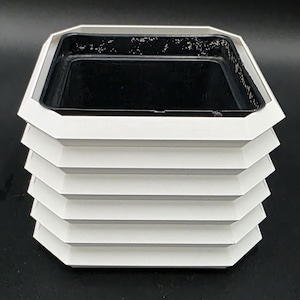 May include: A white ceramic mug with a black handle and the text "But First, Coffee" in a handwritten style. The mug is on a white surface. The mug is 4 inches tall.